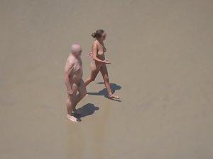 Zooming on weird nudist couple on beach Picture 5