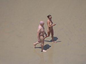 Zooming on weird nudist couple on beach Picture 6