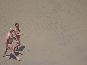 Zooming on weird nudist couple on beach Picture 8