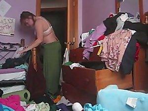 Chubby woman changes in a messy room