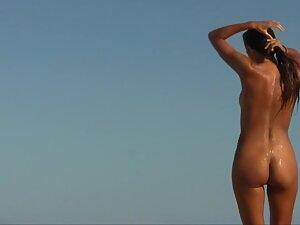 Wet nudist girl gets a hug on the beach Picture 1