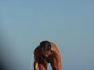 Wet nudist girl gets a hug on the beach Picture 4