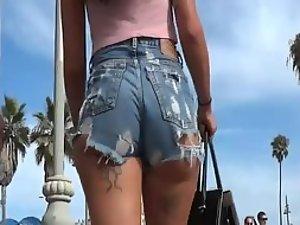 Tattooed girl in torn jeans shorts