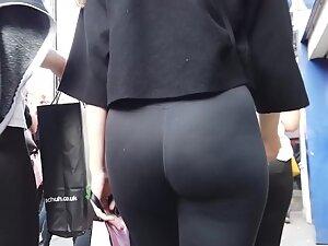 Voyeur focuses on hot ass in black leggings