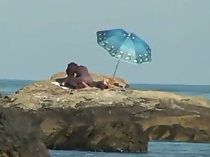 They fuck while alone on a beach rock