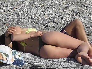 Checking her booty while she cuddles with boyfriend on beach Picture 1