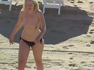 Milf spied while topless on a beach