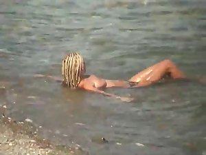 Guy splashes a topless girl with water Picture 4