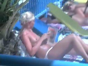 Topless girl reading by the pool Picture 2
