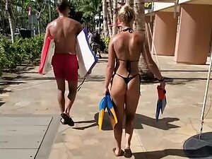 Looking hot in tiny black thong bikini and flippers in her hand