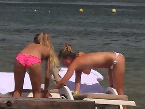Topless girls relaxing by the beach