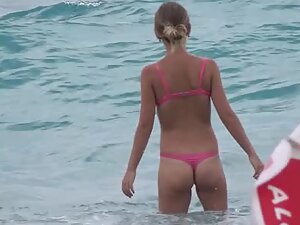 Voyeur checks tiny buttocks in a pink bikini from far away