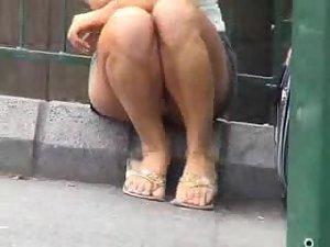Upskirt of a girl sitting on a road curb Picture 6