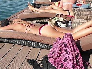 Inspecting her body while she suntans on beach deck Picture 3
