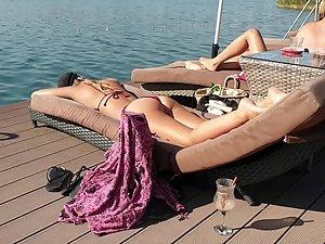 Inspecting her body while she suntans on beach deck Picture 6