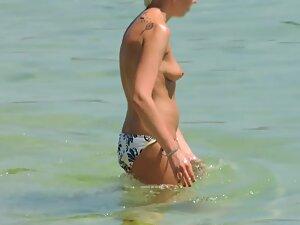 Perky tits of topless woman entering the water Picture 2
