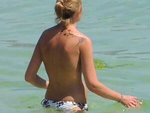 Perky tits of topless woman entering the water Picture 3