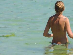 Perky tits of topless woman entering the water Picture 5