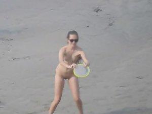 Sporty nudist girl plays frisbee on the beach Picture 5