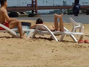 Voyeur checks out lucky guy's curvy girlfriend on beach