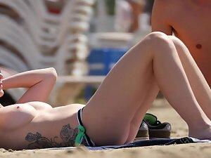 Tattooed girl got big tits in topless on the beach Picture 6