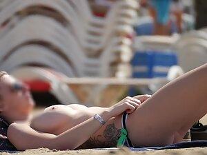 Tattooed girl got big tits in topless on the beach Picture 7