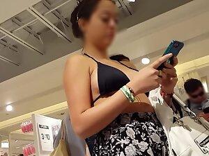 Tattooed girl is wearing a bikini top in shopping mall