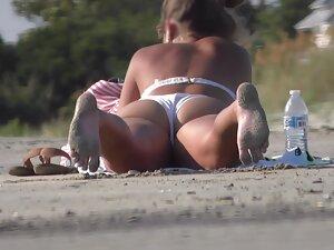 Beach voyeur zooms in on phat pussy in white bikini