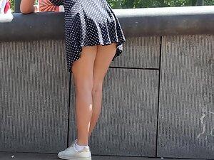 Wind shows upskirt of a busy girl Picture 1