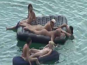 Nude people floating on air mattresses