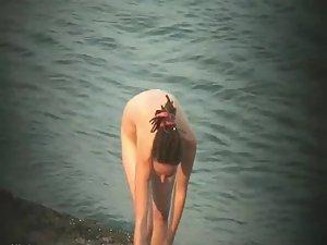 Nude hippie woman getting out of water Picture 5
