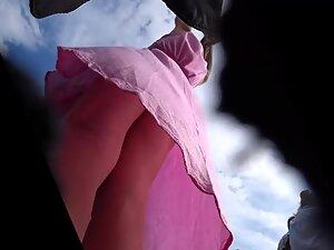 Upskirt under pink dress shows she isn't wearing panties Picture 1