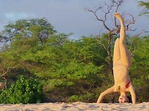 Playful teen girl does headstand on beach Picture 2