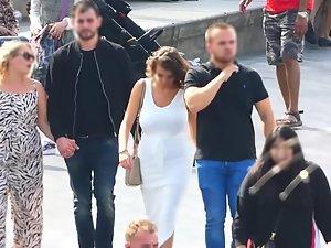 Busty tanned woman in tight white dress Picture 1