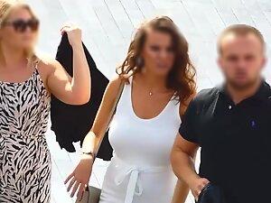 Busty tanned woman in tight white dress