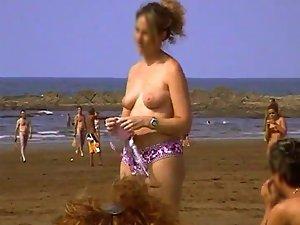 Woman undresses at a nudist beach Picture 6