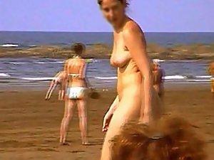 Woman undresses at a nudist beach