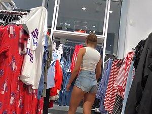 Sexy milf in tiny shorts is browsing the clothes store Picture 6