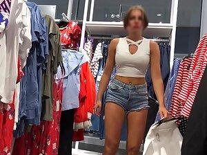 Sexy milf in tiny shorts is browsing the clothes store