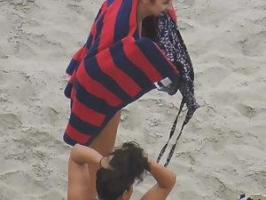 Beautiful woman gets dressed on beach Picture 1