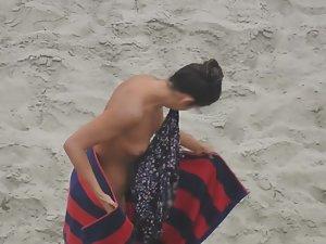 Beautiful woman gets dressed on beach Picture 2