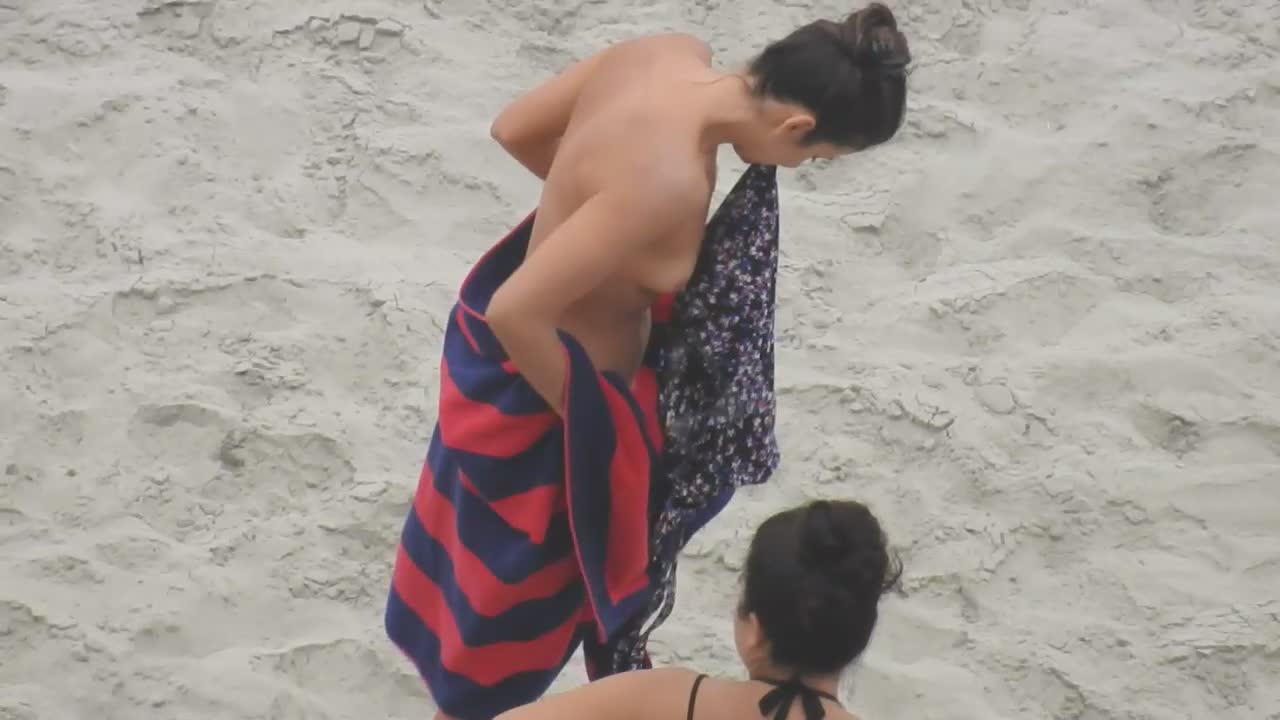 Beautiful woman gets dressed on beach