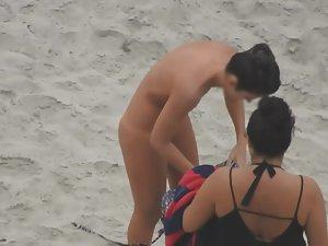 Beautiful woman gets dressed on beach Picture 5