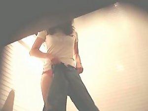 Skinny girl spied putting her pants on