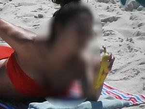 Spicy latina eats a banana on the beach Picture 2