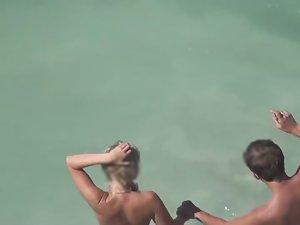 Naked couple stepping in the water Picture 1