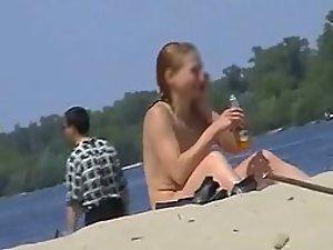 Cute topless girl smoking on a beach Picture 1